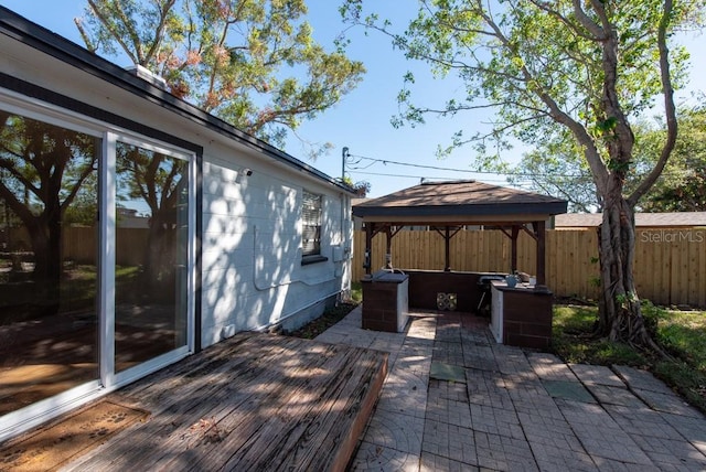 wooden deck featuring a gazebo, cooling unit, and a patio area