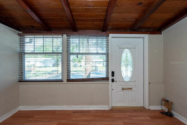 foyer entrance with a wealth of natural light, hardwood / wood-style floors, beamed ceiling, and wooden ceiling