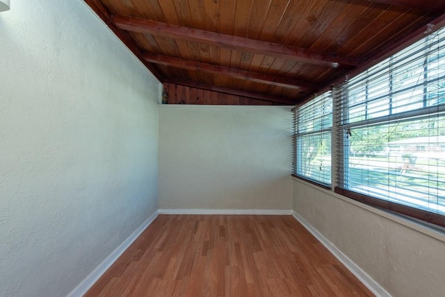 spare room featuring vaulted ceiling with beams, wood ceiling, and light wood-type flooring