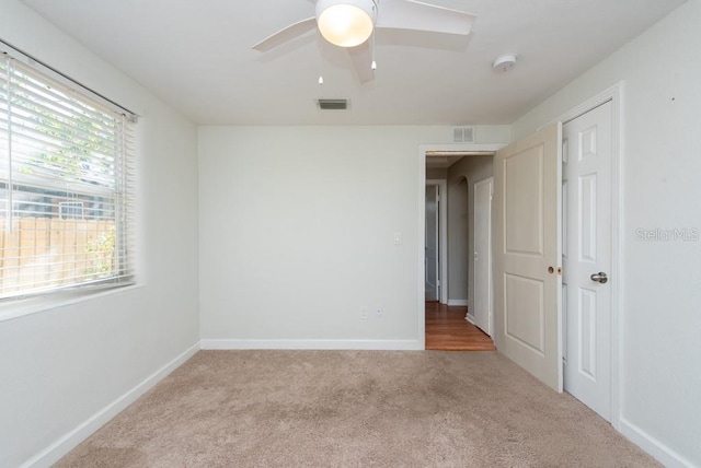 unfurnished room with light carpet and ceiling fan