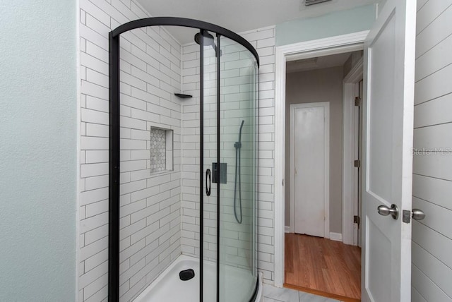 bathroom with hardwood / wood-style floors and a shower with door