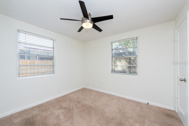 carpeted spare room featuring ceiling fan