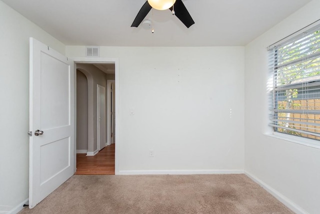 unfurnished room with ceiling fan and light colored carpet