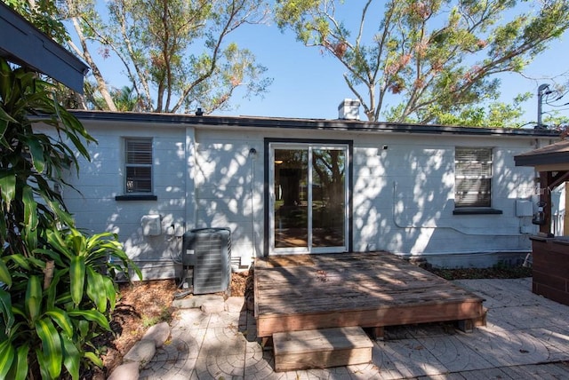 rear view of property with central air condition unit and a wooden deck