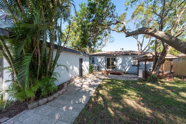 rear view of house featuring a gazebo and a yard