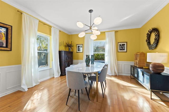 dining area featuring light wood-type flooring, a notable chandelier, and ornamental molding