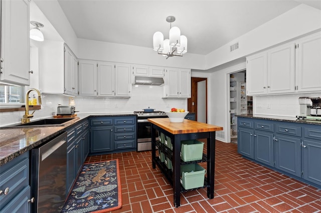 kitchen featuring blue cabinetry, white cabinetry, sink, tasteful backsplash, and appliances with stainless steel finishes