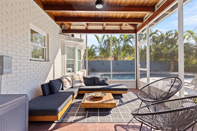 sunroom featuring beam ceiling, a wealth of natural light, and wood ceiling