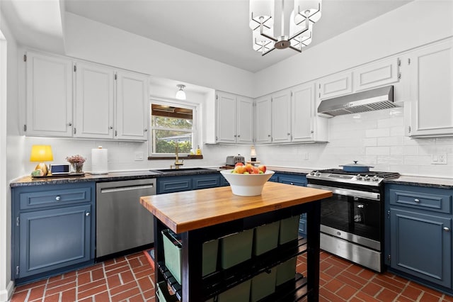 kitchen featuring sink, blue cabinetry, white cabinetry, stainless steel appliances, and extractor fan