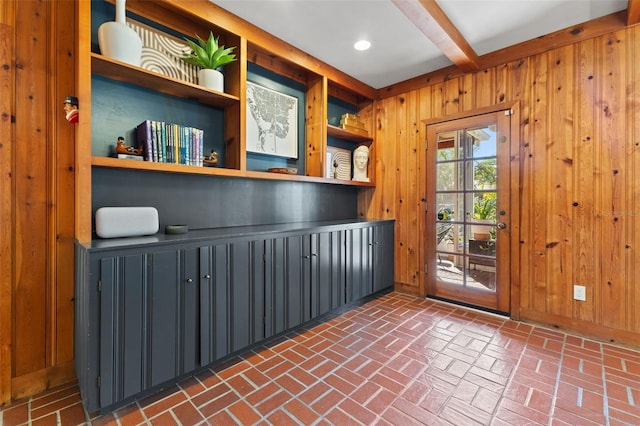 entryway with wood walls and beam ceiling