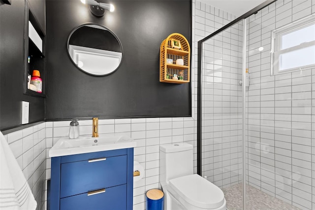 bathroom with an enclosed shower, vanity, toilet, and tile walls