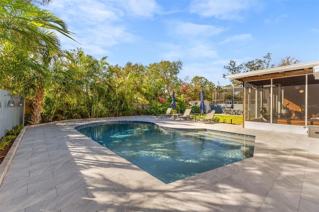 view of pool with a sunroom and a patio