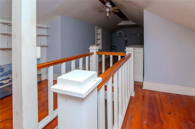 corridor featuring vaulted ceiling, hardwood / wood-style floors, and an upstairs landing