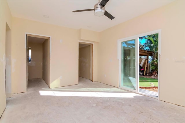 unfurnished bedroom with access to outside, a ceiling fan, and unfinished concrete flooring