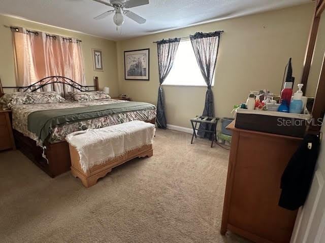 bedroom featuring light colored carpet and ceiling fan