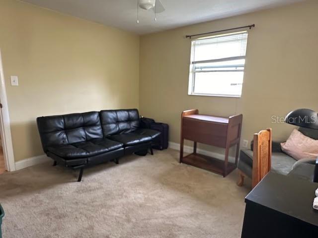 sitting room featuring light carpet and ceiling fan