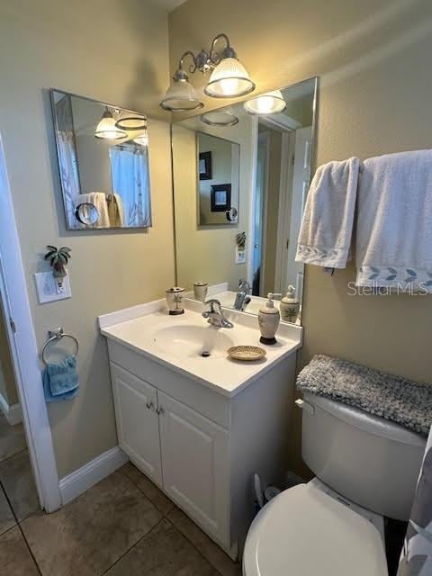 bathroom featuring tile patterned floors, vanity, and toilet