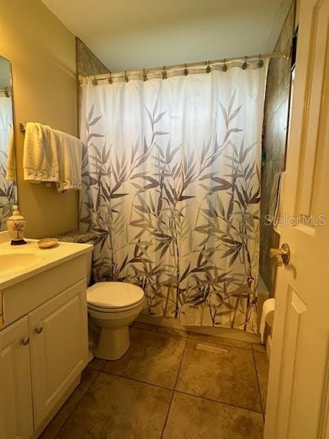 full bathroom featuring tile patterned flooring, vanity, shower / bath combo, and toilet