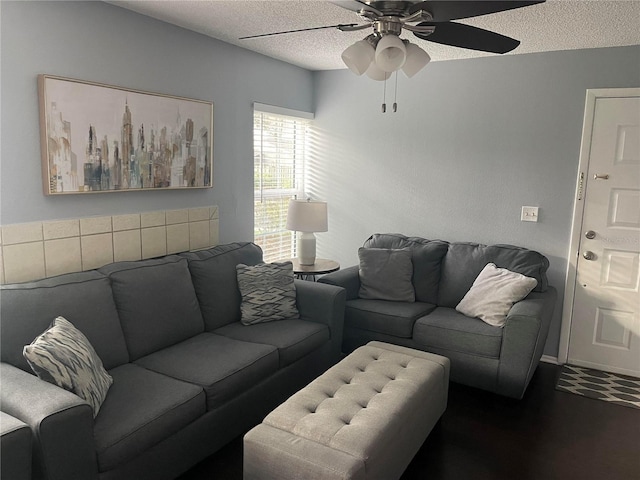 living room with dark hardwood / wood-style floors, ceiling fan, and a textured ceiling