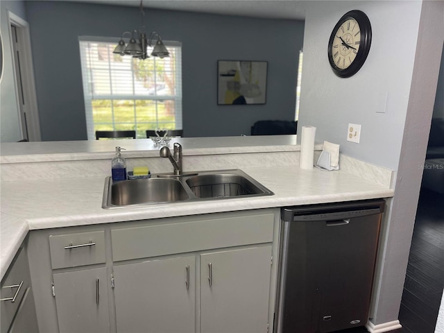 kitchen with stainless steel dishwasher, a notable chandelier, pendant lighting, and sink