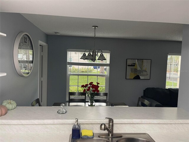 kitchen with sink, pendant lighting, and an inviting chandelier