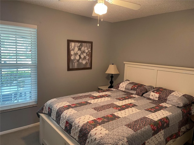 bedroom featuring carpet flooring, a textured ceiling, and ceiling fan