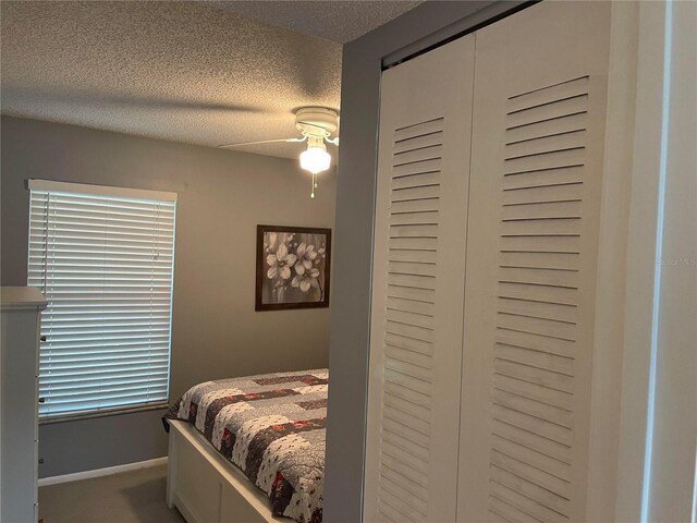 bedroom with ceiling fan, a closet, and a textured ceiling