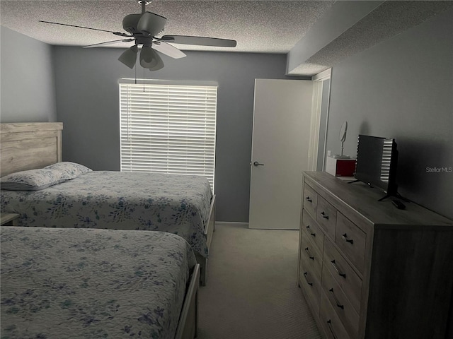 carpeted bedroom featuring ceiling fan and a textured ceiling