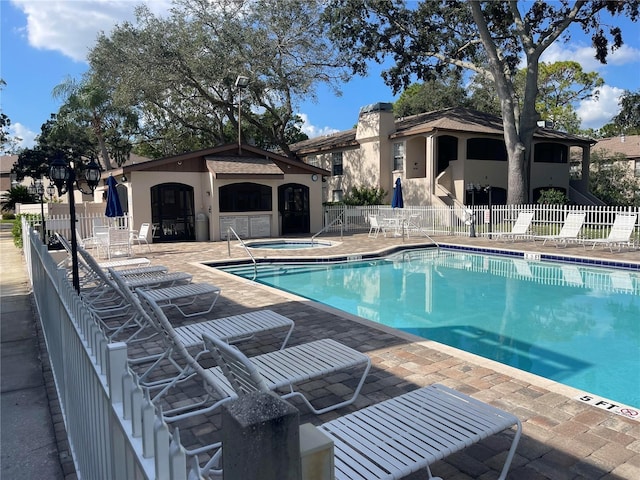 view of swimming pool with a hot tub and a patio area