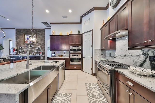 kitchen featuring light stone countertops, appliances with stainless steel finishes, ornamental molding, pendant lighting, and light tile patterned floors