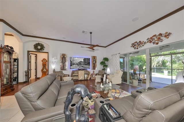 tiled living room with ceiling fan and crown molding