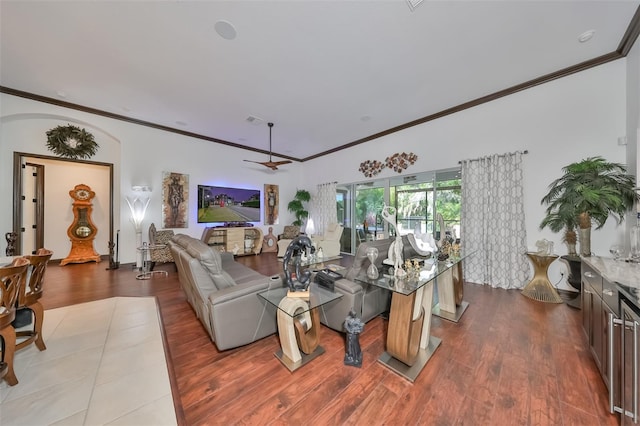 living room with ceiling fan, light wood-type flooring, and crown molding