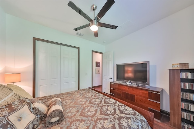 bedroom with ceiling fan, dark wood-type flooring, and a closet