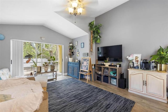 living room featuring ceiling fan, vaulted ceiling, and light wood-type flooring