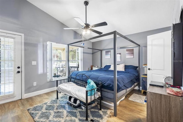 bedroom with hardwood / wood-style flooring, ceiling fan, access to outside, and vaulted ceiling