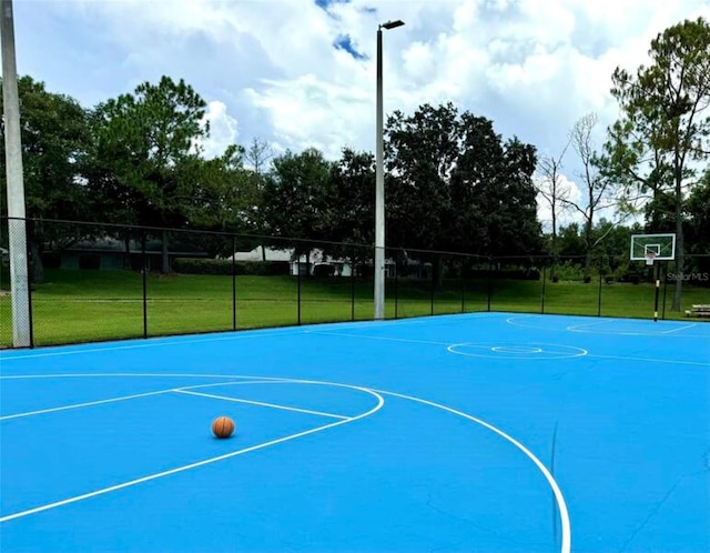 view of sport court featuring a lawn