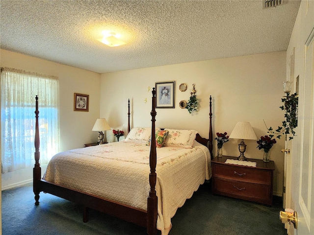 bedroom featuring dark colored carpet and a textured ceiling