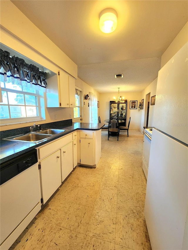 kitchen featuring kitchen peninsula, white cabinetry, sink, and white appliances