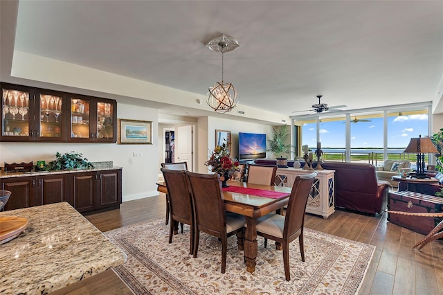 dining space featuring wood-type flooring and ceiling fan with notable chandelier