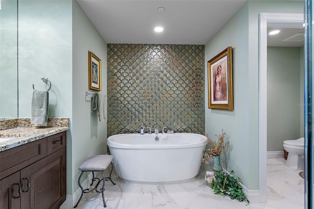 bathroom featuring a bathing tub, vanity, and toilet