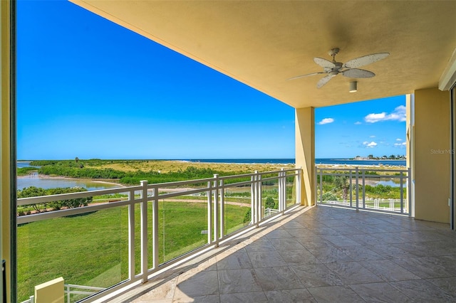 balcony featuring ceiling fan and a water view