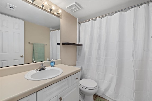 full bathroom featuring toilet, vanity, and visible vents