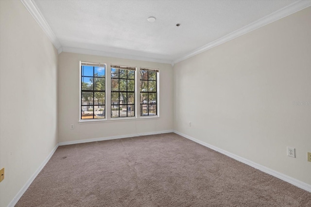 carpeted empty room featuring baseboards and ornamental molding