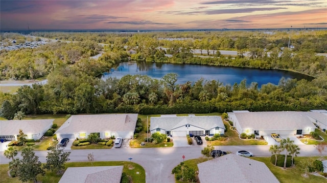 aerial view at dusk featuring a water view