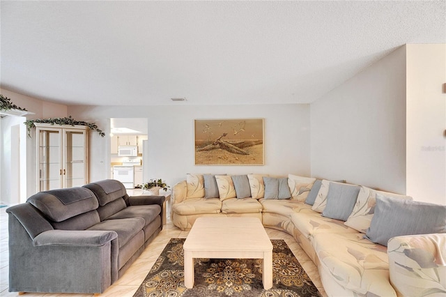 tiled living room featuring a textured ceiling