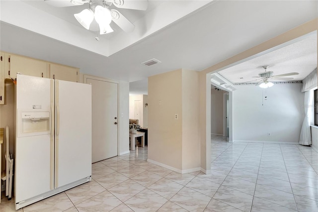 kitchen with cream cabinetry, ceiling fan, and white refrigerator with ice dispenser