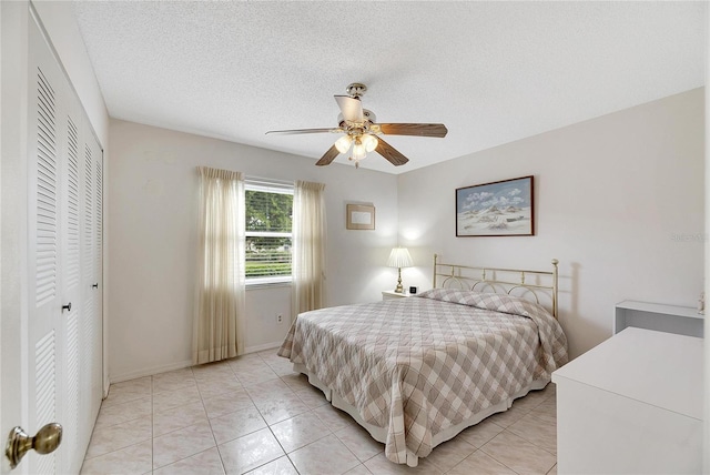 tiled bedroom with a textured ceiling, a closet, and ceiling fan