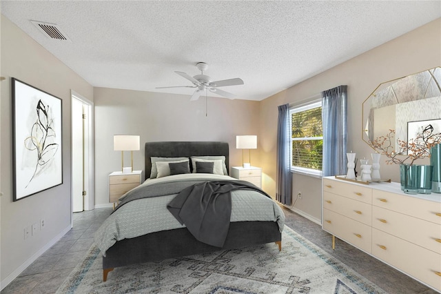 tiled bedroom featuring ceiling fan and a textured ceiling