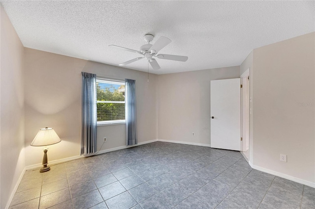 unfurnished room with ceiling fan, light tile patterned floors, and a textured ceiling