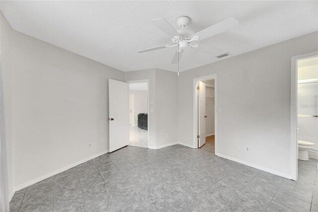 empty room with ceiling fan and a textured ceiling